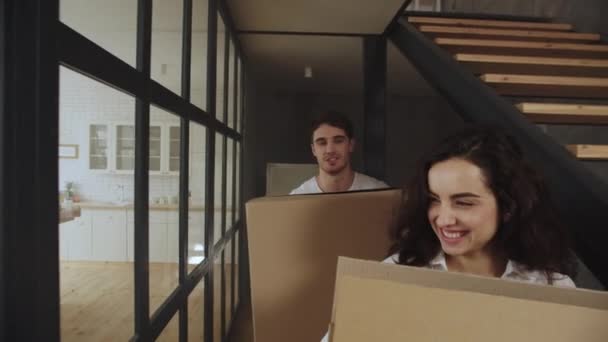 Joyeux couple avec des boîtes déménageant dans un nouvel appartement. Couple étreignant à la cuisine . — Video
