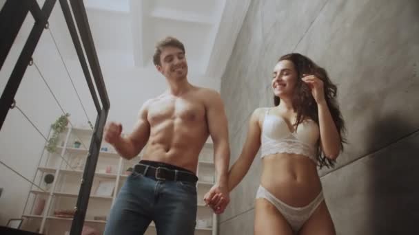 Sexy couple walking down stairs at home. Happy couple after sex — Stock Video