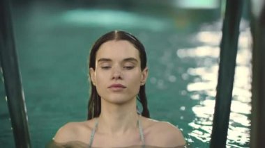 Yakından bir kadın bilardoda kameraya bakıyor. Ağır çekimde havuz başında yıkanan kız