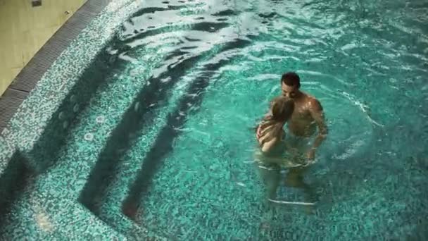 Jong stel samen badend. Sexy paar flirten in zwembad spa. — Stockvideo