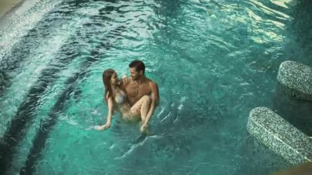 Vista superior do casal feliz desfrutando da piscina. Casal alegre relaxante no hotel de bem-estar — Vídeo de Stock