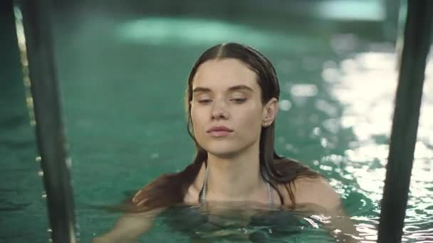 Macro de mujer bonita nadando en la piscina. Sexy chica mirando en la cámara . — Vídeo de stock