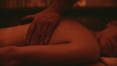 Erkek ellerinin yavaş çekimde masaj yapmasını. Kadın vücudu masaj yaptırıyor.