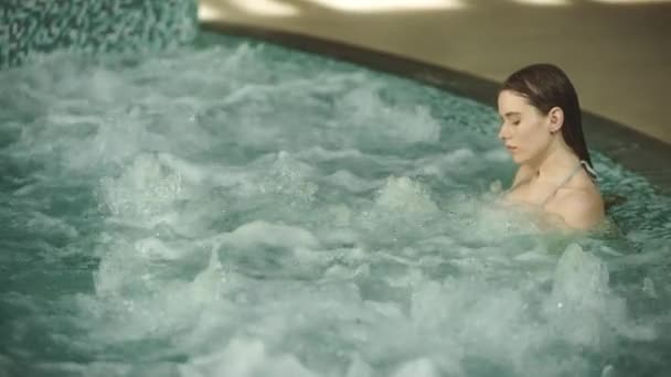 Closeup young woman relaxing in whirlpool bath. Beautiful girl enjoying jacuzz — Stock Video