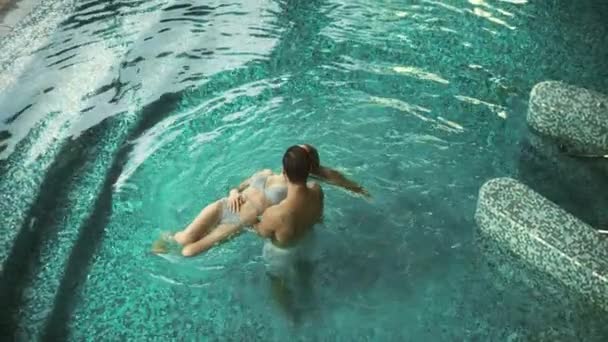 Top view couple enjoying pool at spa hotel. Couple resting in pool at spa — Stock Video