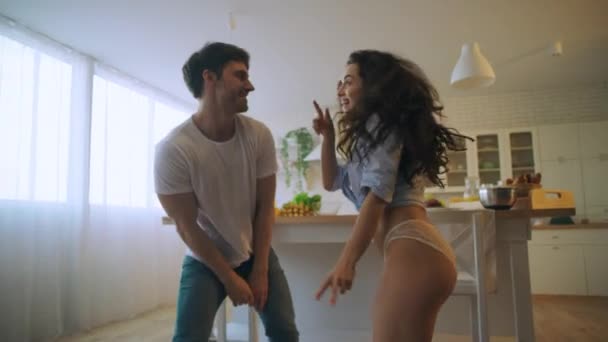 Pareja joven bailando en la cocina casera. Macro de mujer moviendo nalgas . — Vídeos de Stock