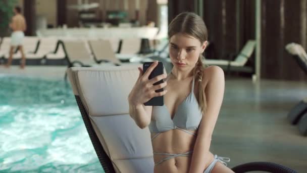 Retrato de mulher bonita fazendo selfie perto da piscina. Menina enviando beijo de ar — Vídeo de Stock