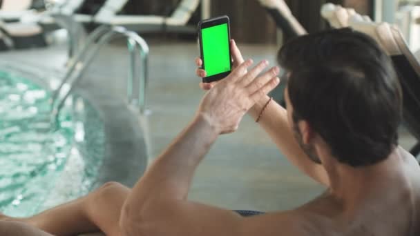 Primer plano hombre guapo que tiene videollamada con teléfono de pantalla verde. Hombre con teléfono — Vídeo de stock