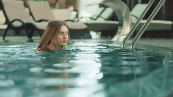 Jolie femme buvant un cocktail au bord de la piscine à l'hôtel. Femme nageant dans la piscine — Video