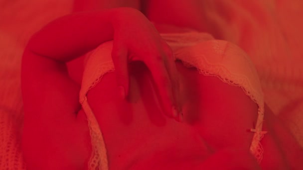 Close-up sexy vrouw liggend in lingerie in rood licht kamer. Top uitzicht van hete vrouw — Stockvideo