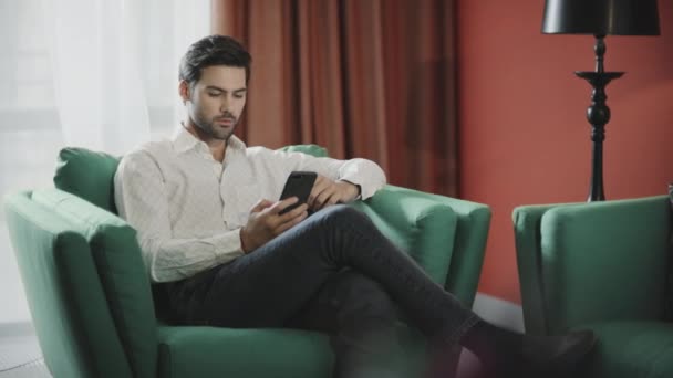 Geschäftsmann scrollt Handy im Luxushotel. Geschäftsmann liest Telefon — Stockvideo