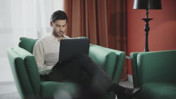 Snygg affärsman som jobbar med laptop på hotellet. Arbetsdator för affärsman — Stockvideo