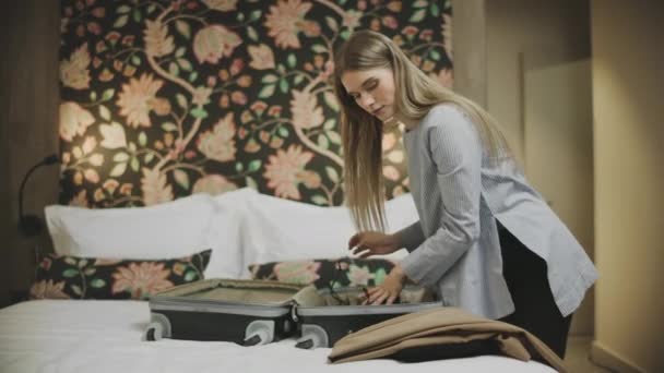 Bella donna che fa i bagagli alla tuta dell'hotel. Sexy ragazza chiusura valigia in hotel . — Video Stock
