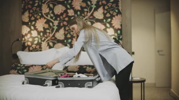 Söt kvinna öppnar bagaget på hotellrummet. Attraktiv kvinna packa upp resväska — Stockvideo