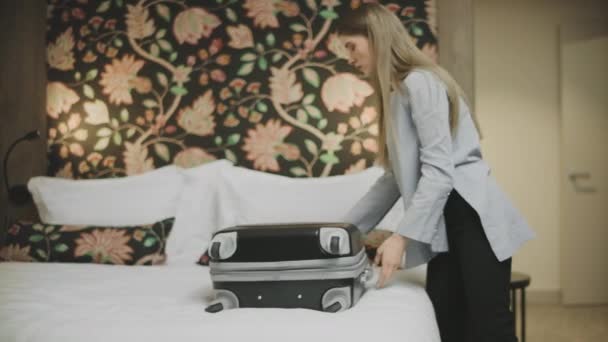 Csinos nő zárja a bőröndöt. A lány leteszi a nehéz bőröndöt — Stock videók