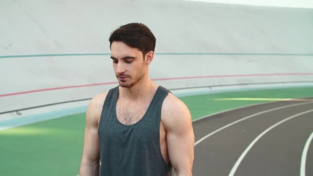 Retrato del deportista usando reloj inteligente en la pista. Hombre corredor comprobar los resultados — Vídeo de stock