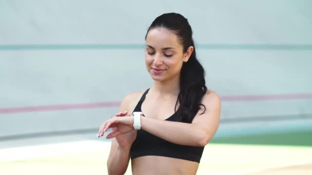 Retrato de corredor femenino usando reloj inteligente en el estadio — Vídeo de stock