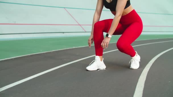 Deportiva mujer atando zapatillas de deporte para el entrenamiento en pista. Mujer corredor atar los zapatos — Vídeos de Stock