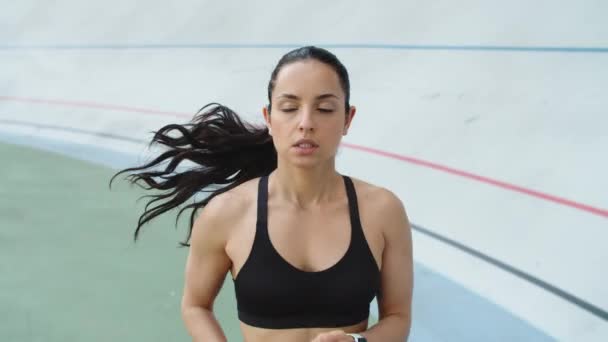 A női futó lassított felvételen fut a versenypályán. Fitness lány kocogás — Stock videók
