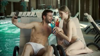 Kapalı kapılar ardında kokteyl içen bir çift. Erkek ve kadın spa 'da selfie çekiyor.