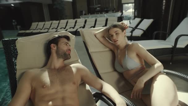 Κοντινό ζευγάρι που μιλάει σε ξαπλώστρες δίπλα στην πισίνα. Άντρας και γυναίκα μιλούν κοντά στην πισίνα — Αρχείο Βίντεο