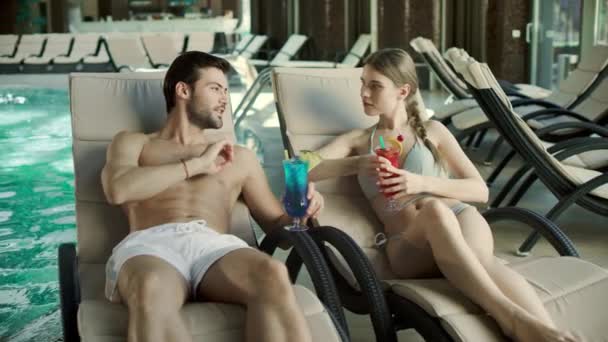 Pareja cercana bebiendo cócteles en tumbona. Hombre y mujer coqueteando juntos — Vídeo de stock