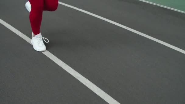 Primer plano de las piernas de mujer deportiva corriendo en el estadio. Mujer pies corriendo en zapatos — Vídeo de stock