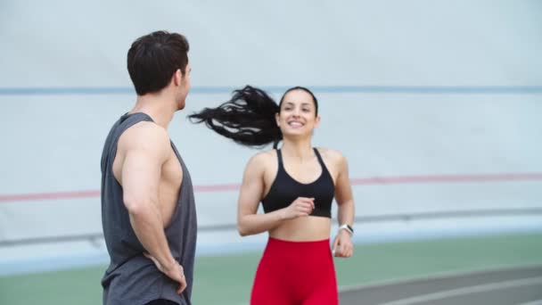 Mulher a correr na pista de corrida. Treinador homem formação mulher no estádio — Vídeo de Stock