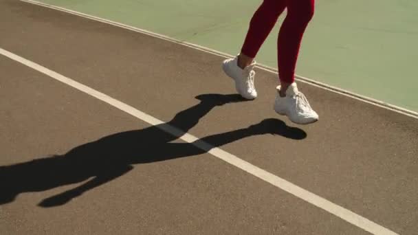 Close-up vrouwelijke voeten joggen in trainers op de rails. Meisje loopt buiten op de rails — Stockvideo