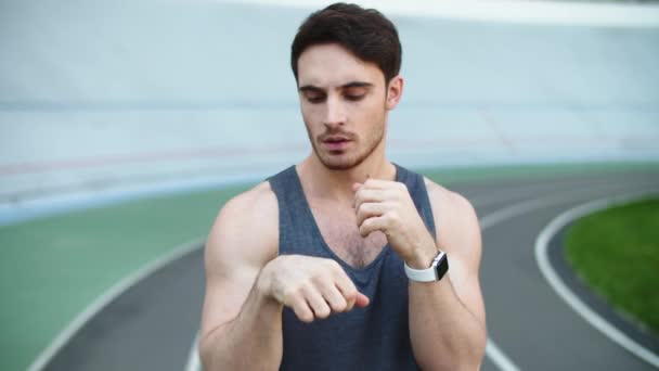 Sportos férfi nyújtja a karját edzés előtt. Az atlétikai stadionban gyakorló férfi — Stock videók