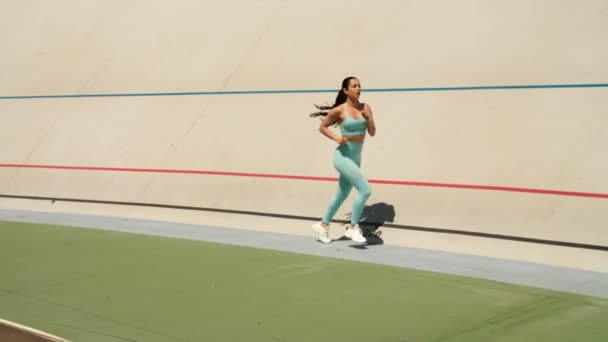 Stadyumdaki atletizm pistinde seksi kadın antrenmanı. Koşan atlet kadın. — Stok video