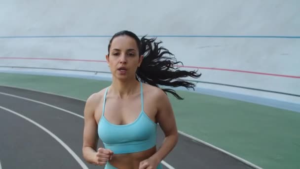 Mulher atleta correndo na pista de atletismo. Retrato de corredor feminino correndo — Vídeo de Stock