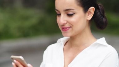Yakın plan kadın akıllı telefondan internete göz atıyor. Dışarıda cep telefonu kullanan bir kız.