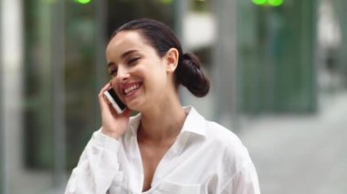 Kapanış kızı dışarıda telefonla konuşuyor. Dışarıda cep telefonuyla konuşan bir kadın.
