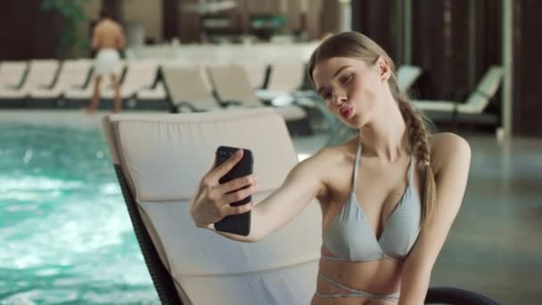 Primo piano bella donna facendo selfie sul lettino vicino alla piscina. Donna in posa per selfie — Video Stock