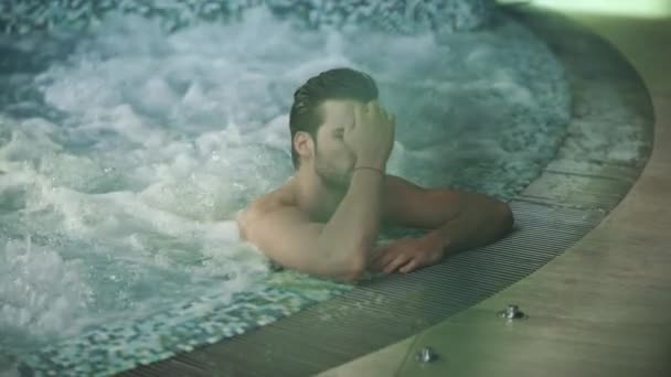 Szexi srác, aki medencében pihen a Spa Hotelben. Férfi megható nedves haj jacuzzi spa — Stock videók