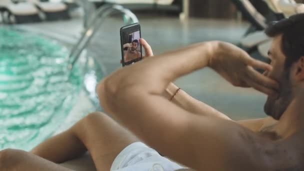 Closeup jovem posando na câmera do telefone perto da piscina em câmera lenta. — Vídeo de Stock