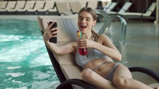 Femme sexy faisant appel vidéo par piscine. Flirter fille boire cocktail. — Video