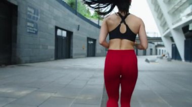 Formda bir kadın ağır çekimde dışarı koşuyor. Seksi kadın antrenmanlarının arka planı