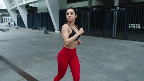 Una joven deportista corriendo por la calle urbana. Sexy mujer coqueteando en trote al aire libre . — Vídeo de stock