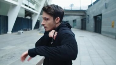 Şehir caddesinde kutu antrenmanı yapan ciddi bir adam. Yakışıklı adam boks yapıyor.