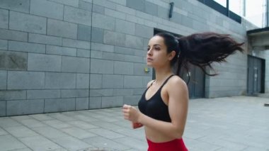 Attractive woman jogging at city street. Sexy girl running at workout outdoor.