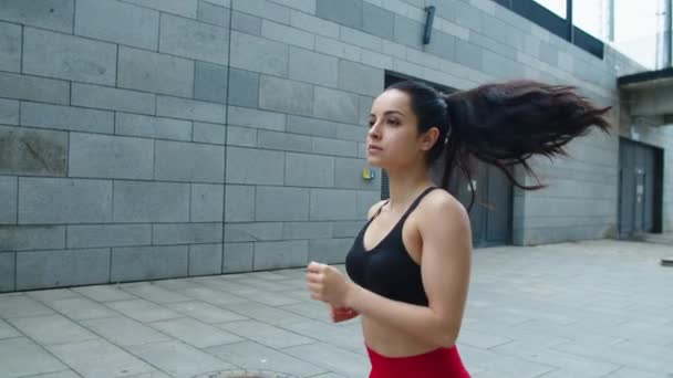 Mujer atractiva corriendo en la calle de la ciudad. Sexy chica corriendo en el entrenamiento al aire libre . — Vídeo de stock