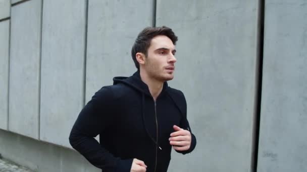 Närbild idrottsman kör utomhus. Snygg kille som springer upp i slow motion — Stockvideo