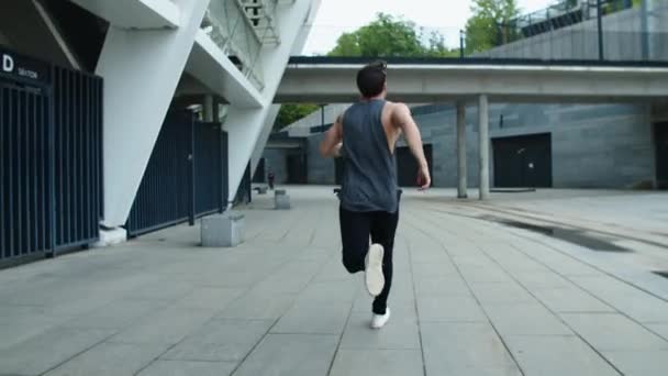 Vue arrière de l'homme sportif courant dans la rue urbaine. Athlète homme jogging extérieur . — Video