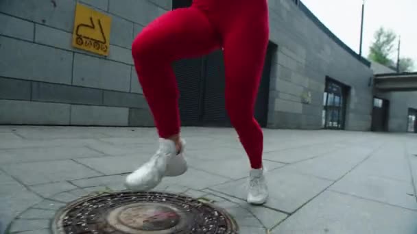 Крупним планом жіночі ноги працюють на міській вулиці. Фітнес жінка закінчує біг — стокове відео