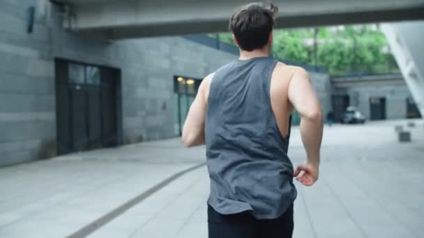 Fit man running outdoor in slow motion. Back view of athlete man training run — Stock Video