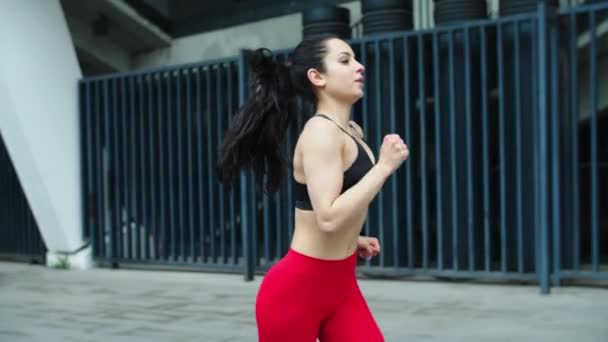 Atractiva corredora corriendo al aire libre. Carrera de entrenamiento de mujer fitness de cerca — Vídeos de Stock