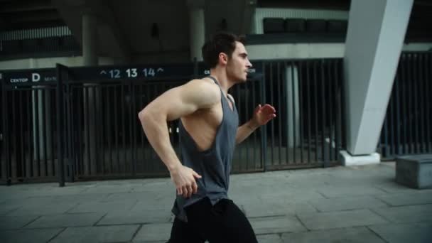 Close up corridore maschile jogging su allenamento all'aperto. Vista laterale dell'uomo in corsa . — Video Stock