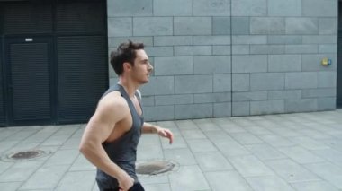Dışarı koşan bir sporcu. Erkek koşucu şehir caddesinde ağır çekimde koşuyor.